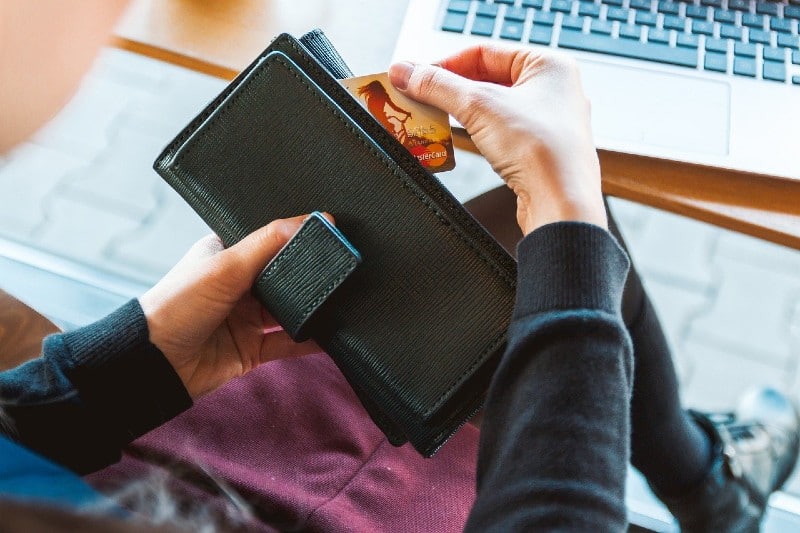 Female hands taking credit card out of wallet to pay