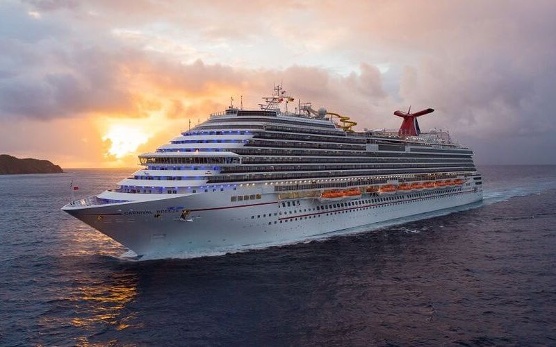 Carnival Breeze sailing the sea with the sunset taking place behind
