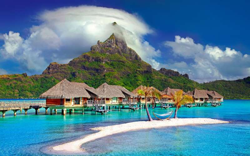 A photo of the Caribbean with the birght blue sea and mountains in the distance.