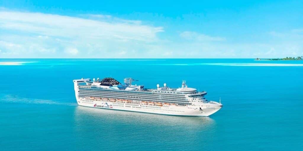 Carnival Adventure cruise ship sailing on a blue ocean.