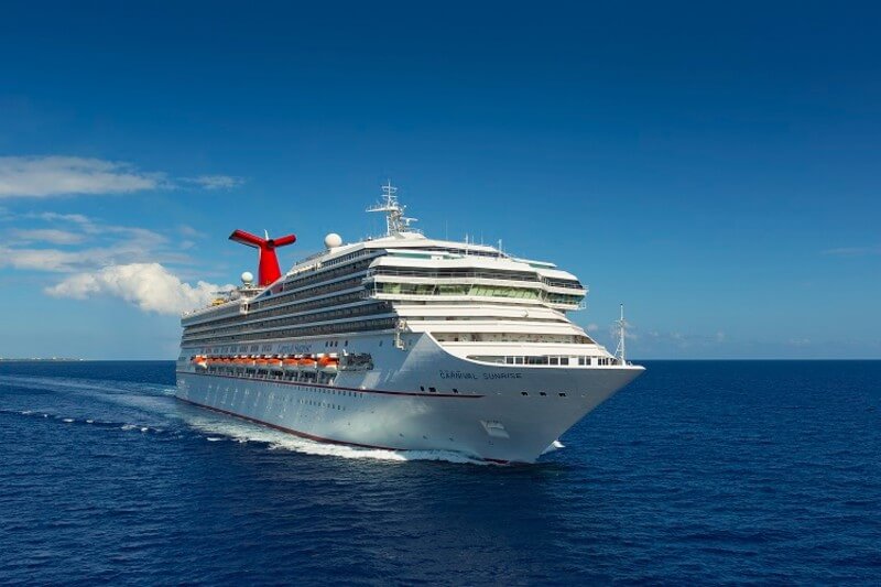 Carnival Sunrise cruising the dark blue ocean under a  clear sky