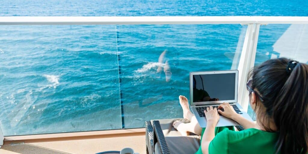 Woman relaxing on cruise ship deck using her laptop