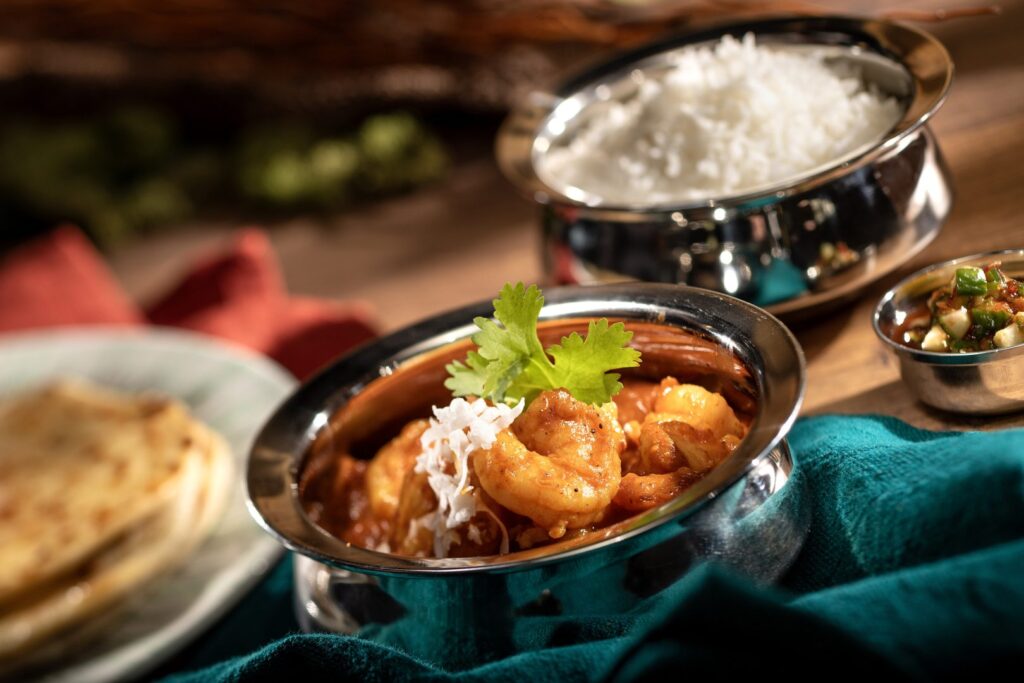 Cape Malay Shrimp Curry – Garam masala, turmeric, cumin-coconut curry sauce, aromatic basmati rice, cucumber sambal, and butter roti