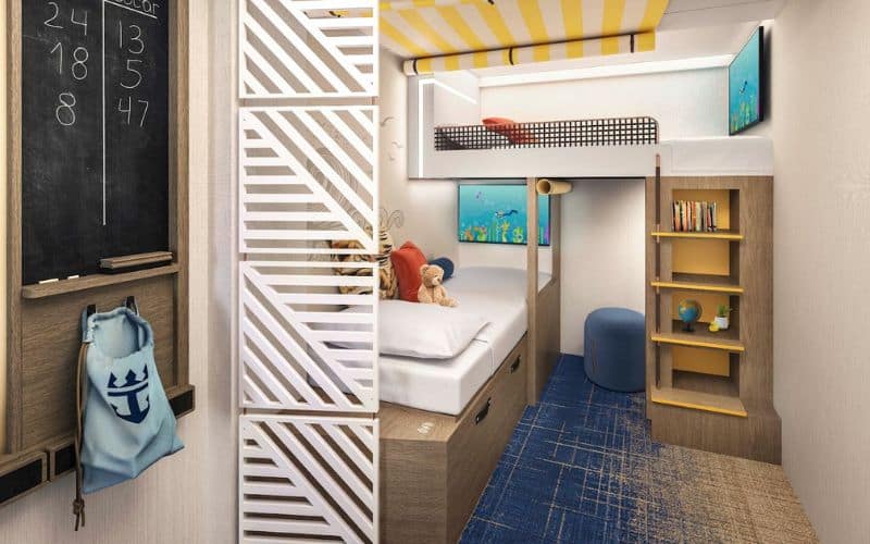 Family-friendly Infinite Ocean View Balcony stateroom on Royal Caribbean's 'Star of the Seas.' The room features a cozy bunk bed setup with a bottom twin bed and a top loft-style bed, a playful yellow-striped ceiling, and nautical-themed décor. A small desk area with a chalkboard, books, and maritime-inspired accessories create a fun and inviting space for children.