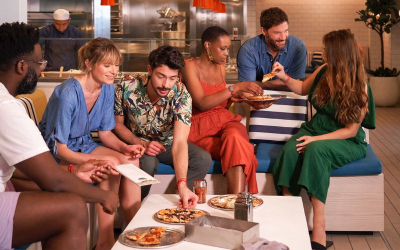 Group eating and being sociable on a Virgin Voyages cruise