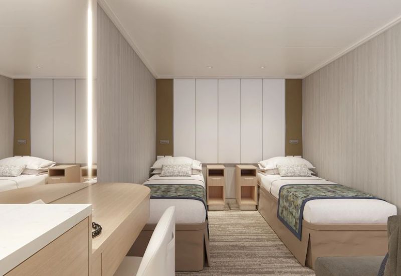 The image shows an interior stateroom on Princess Cruises' Sun Princess. The room features two twin beds with white linens and decorative pillows, separated by a nightstand with open shelving. The walls are light-colored with a simple, modern design, and there is a mirror reflecting part of the room. The overall decor is minimalist and clean, creating a cozy and comfortable atmosphere.