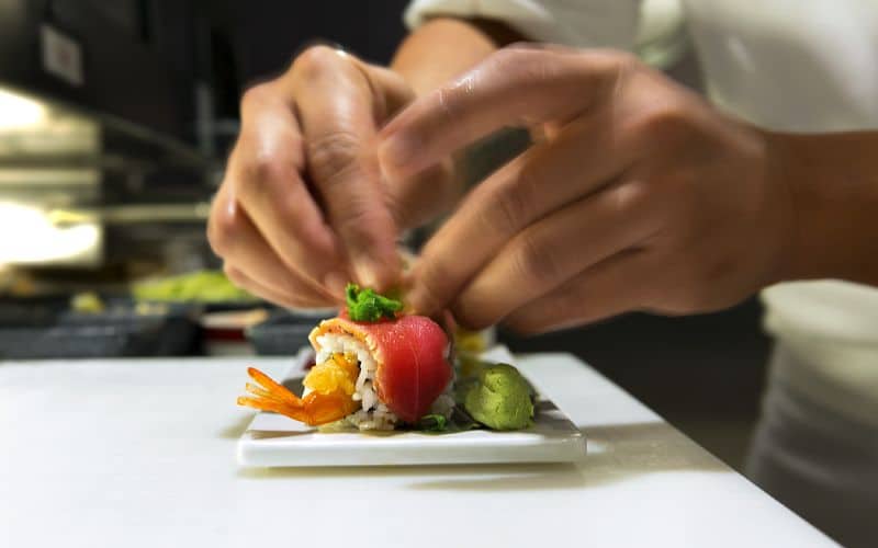 The chef garnishing an order of sushi