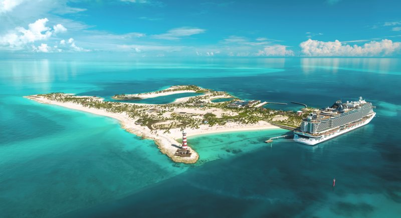 Aerial view of the MSC Seashore cruise ship making its inaugural visit to Ocean Cay MSC Marine Reserve, showcasing the vessel's grand scale beside the picturesque tropical island with lush greenery, pristine beaches, and the iconic lighthouse.