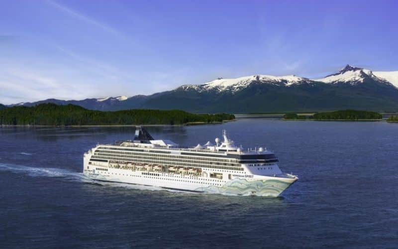 Norwegian Spirit cruise ship sailing on the ocean under clear blue skies.