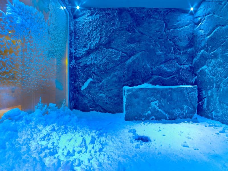 A tranquil Snow Grotto on a Viking Cruise ship, with textured icy walls and soft snow underfoot, illuminated by a cool blue light, offering a unique and refreshing spa experience at sea.