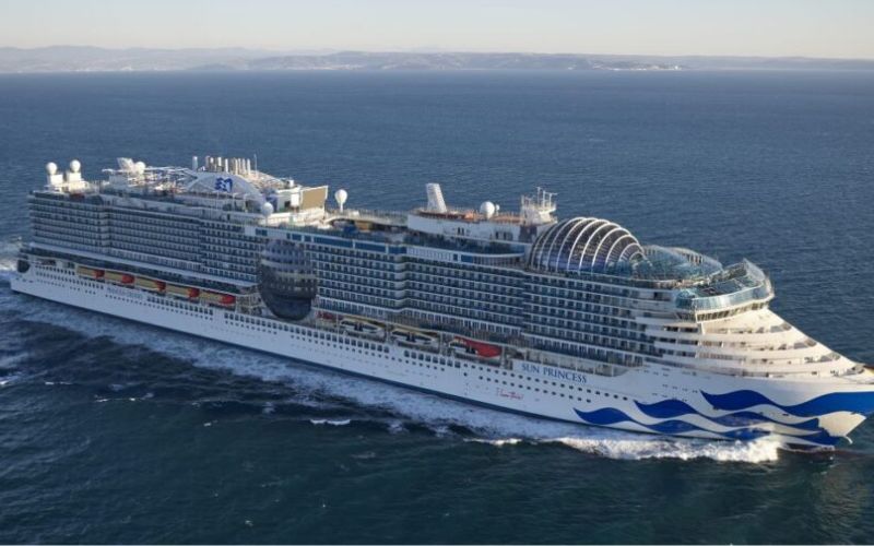 Ocean view of a cruise ship with blue and white stripes. named Sun Princess