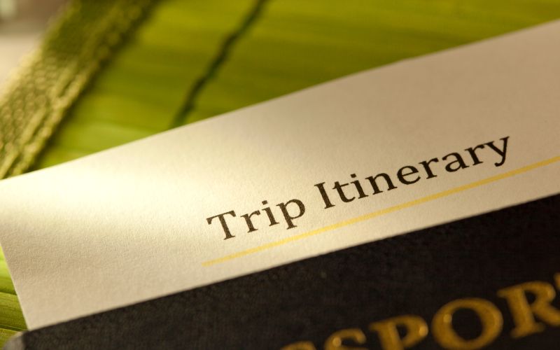 A paper appearing to be a list of the trip itinerary slipped on a passport