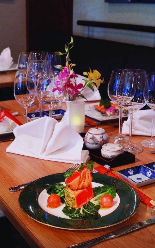 A delicious meal served onboard with flowers as a center ornament.