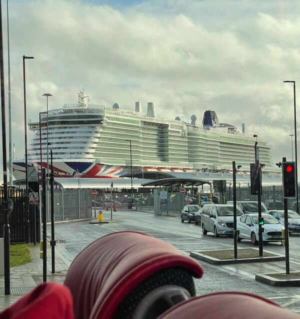 A view of a cruise ship docked at port from inside a coach.