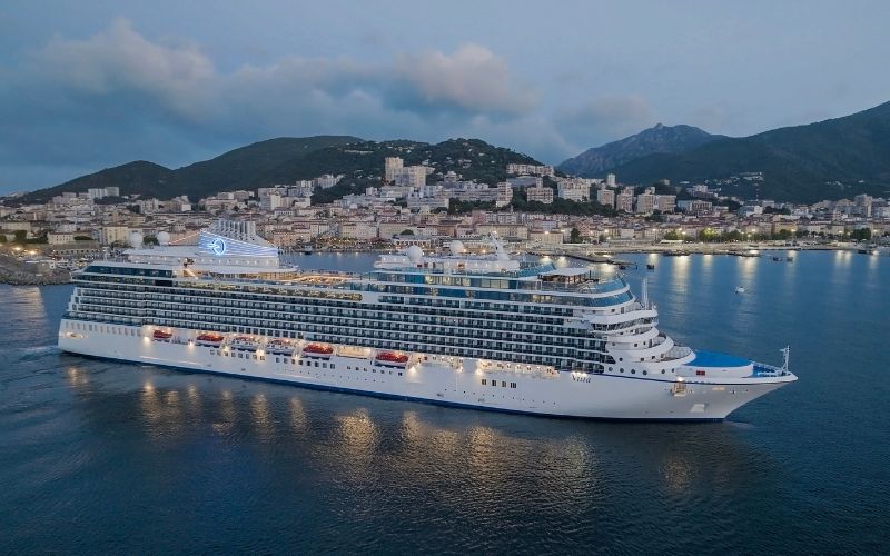 Vista cruise ship from Oceania Cruises leaving  a small island town as the night approach