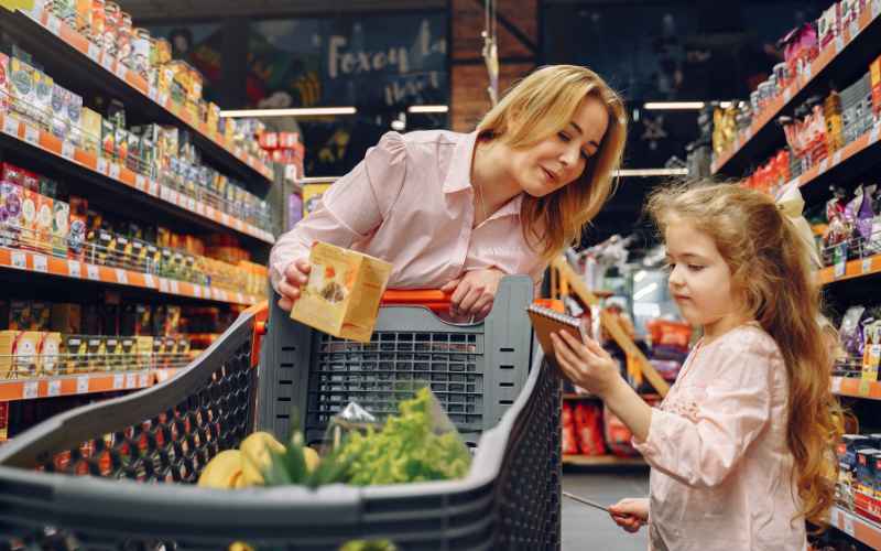 Woman and a girl doing shopping in a supermarket.