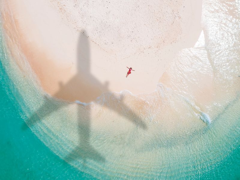 Plane flying over a Caribbean beach