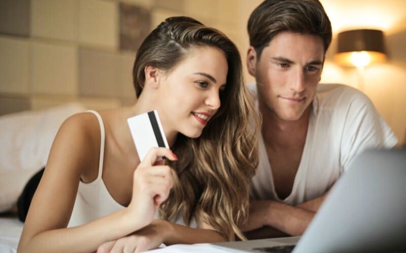 a couple booking their cruise together on a hotel bed