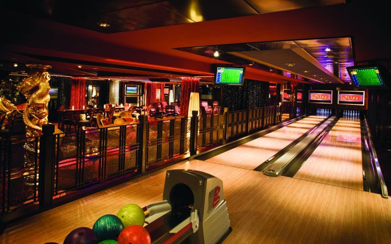 A dimly-lit bowling alley room on one of Norwegian Cruise Line's cruise ship