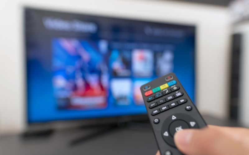 A person trying to use a tv remote with broken buttons on a cruise ship