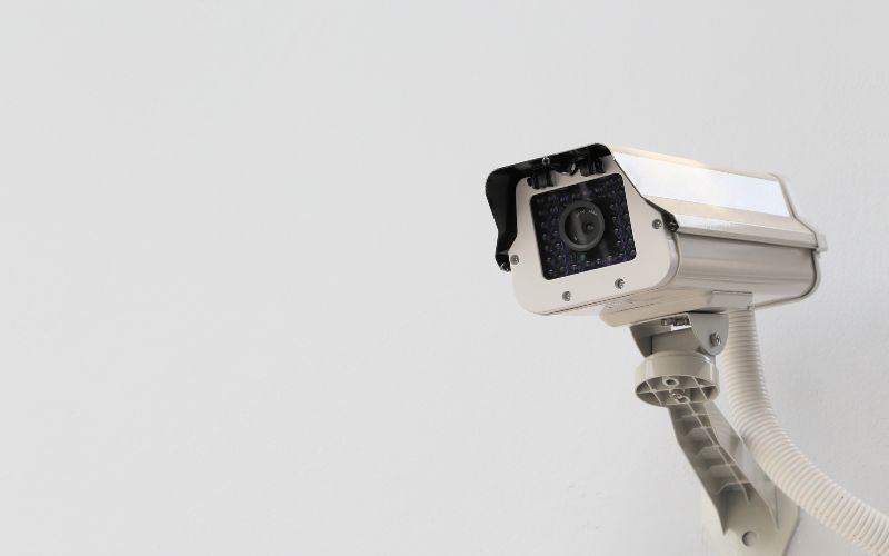 A white cctv camera installed on a white wall on a cruise ship