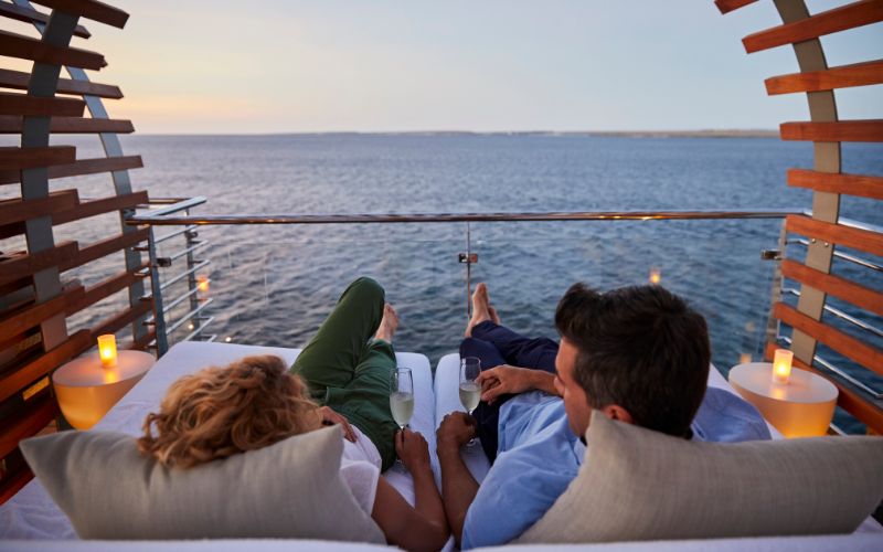Couple sharing a glass of champagne  on Celebrity Cruises balcony