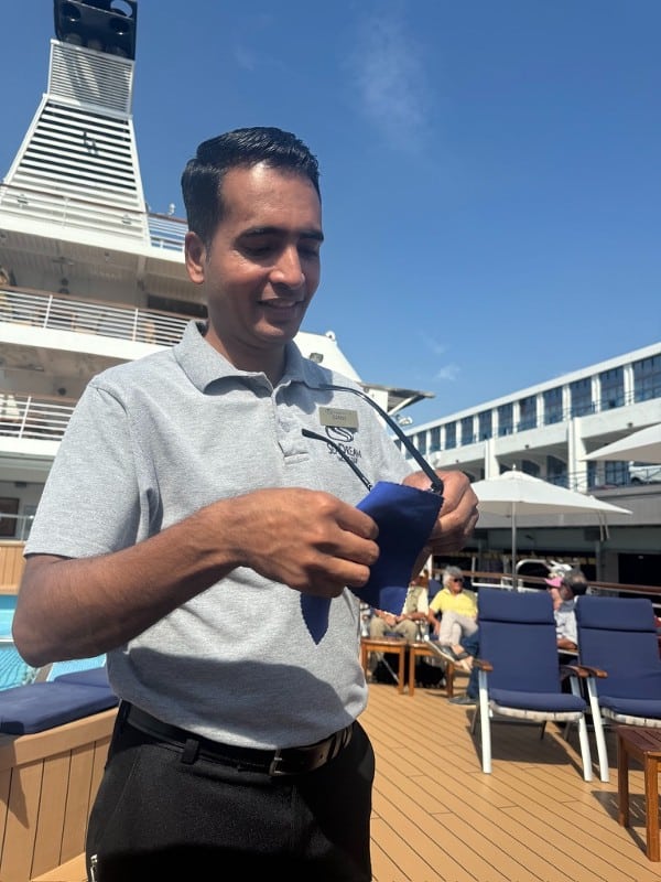 Crew member cleaning sunglasses on SeaDream yacht club