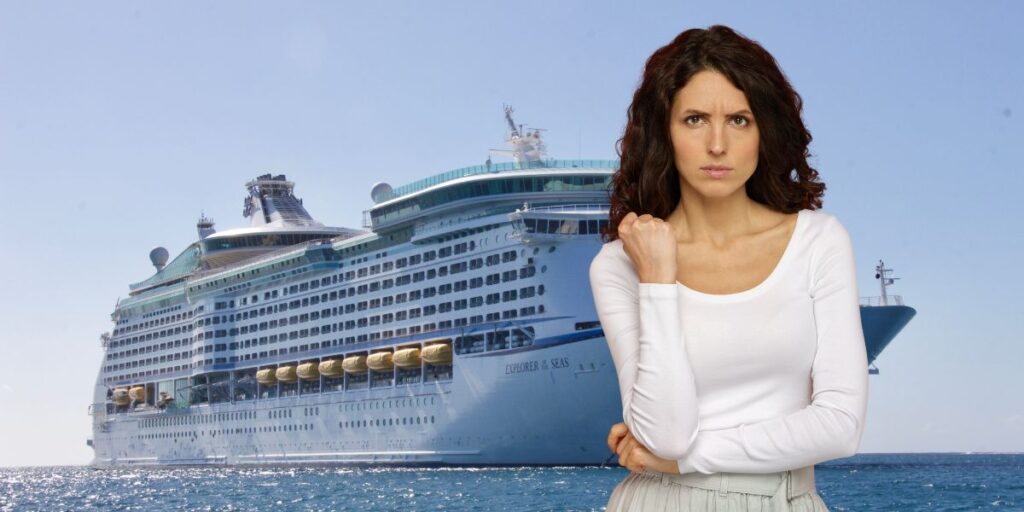 A woman with a serious expression stands in front of a large cruise ship named "Explorer of the Seas." The background features a clear blue sky and the ocean, emphasizing the contrast between the woman's demeanor and the vacation setting.