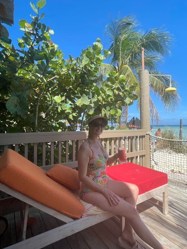 Me holding a drink while relaxing in my cabana