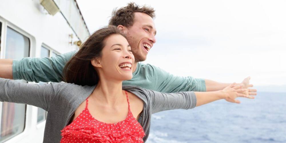 Two people on a cruise enjoying the view and the breeze