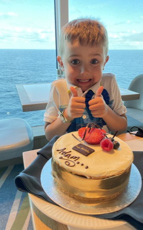 Adam with cake in front of him on his 5th birthday onboard Iona.