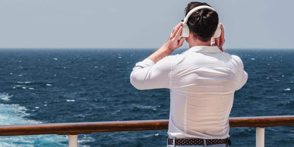 man listening to music on a cruise ship deck