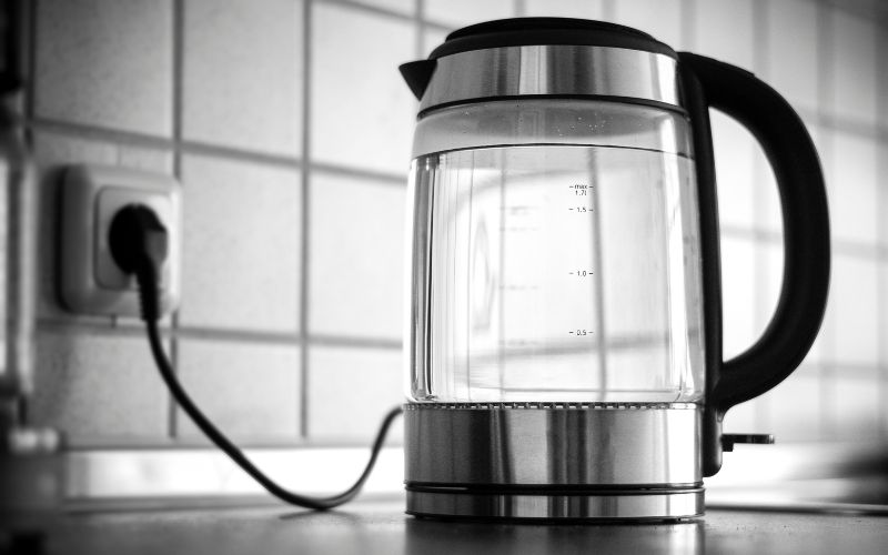 A monochrome shot of a  travel kettle in the kitchen of a cruise ship.